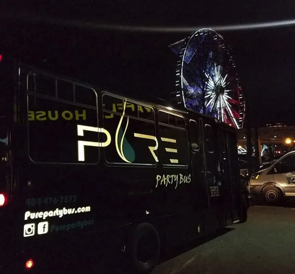 Pure Party Bus at night near the SkyView Atlanta Ferris wheel