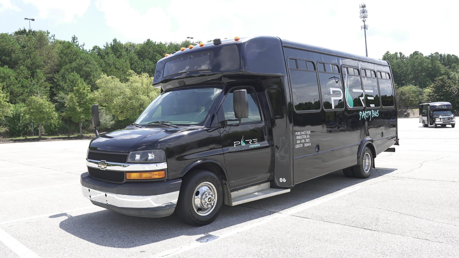 Black Pure Party Bus limo bus with the Pure Party Bus logo and USDOT 3024414 on the side, parked in Mableton, GA
